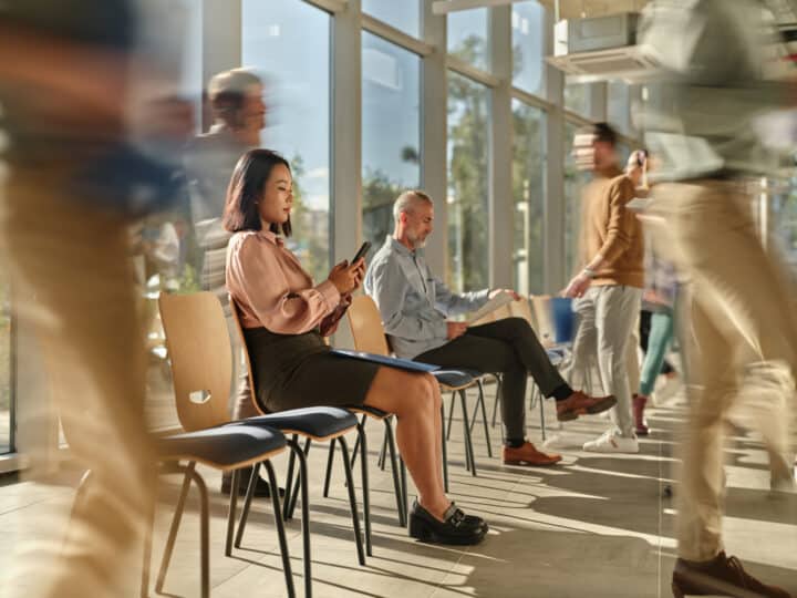 Business people waiting for job interview among their colleagues in blurred motion.
