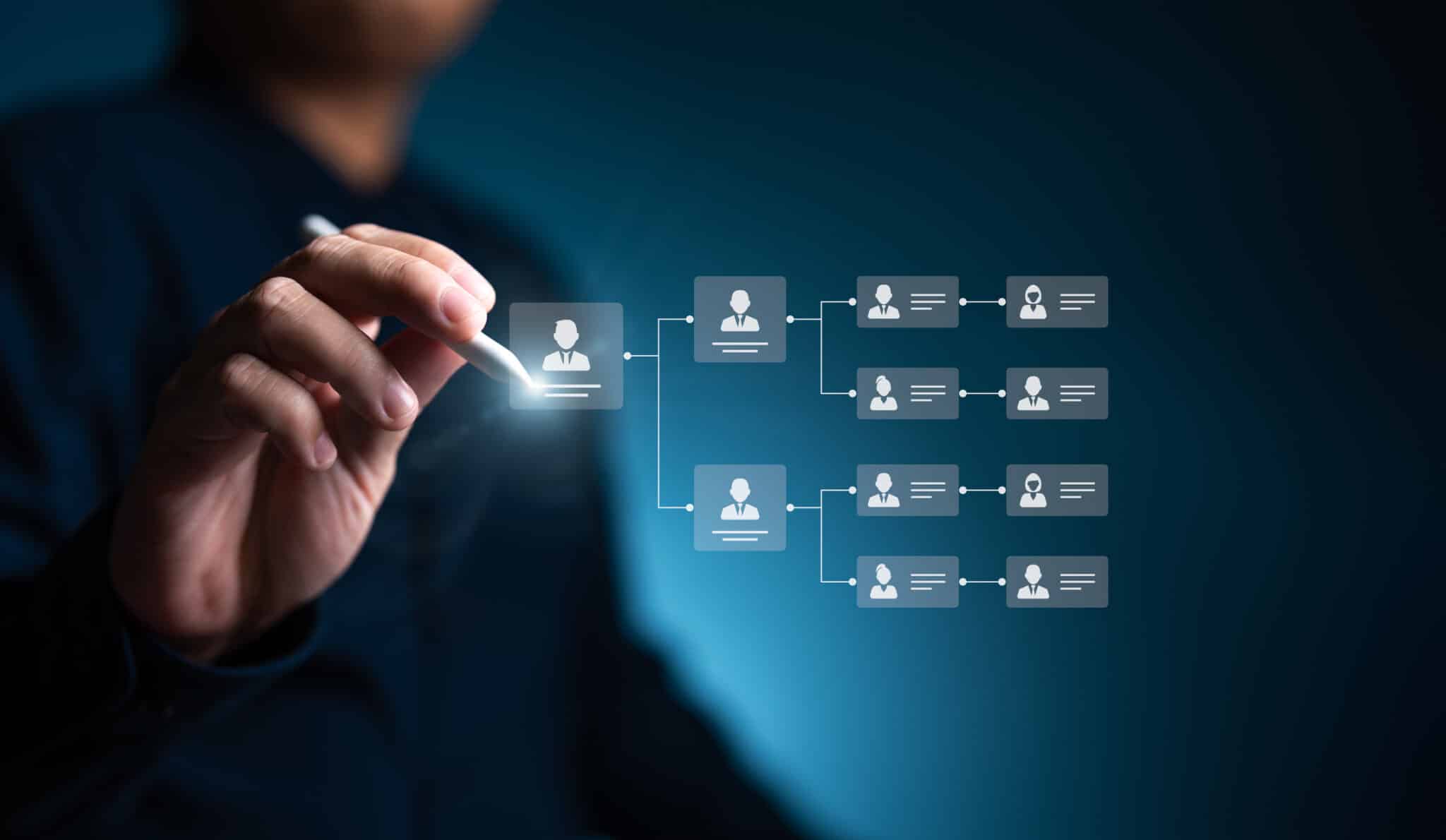 Organization chart, mind map. Businessman uses a pen to draw an organigram on a virtual screen. HR Manager works on HR company structure tree diagram, resource leveling, and career path concepts.